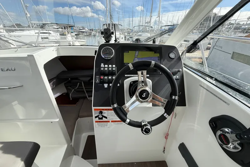 Slide: The Image of Cockpit of 2021 Beneteau Antares 8 with steering wheel and navigation controls. - 9