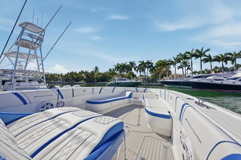 Slide: The Image of 2019 Midnight Express 43 Open boat with luxurious seating, docked near palm trees and yachts. - 10