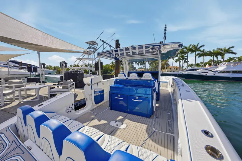 Slide: The Image of 2019 Midnight Express 43 Open boat docked, featuring blue and white seating, sunny marina backdrop. - 12