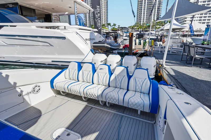 Slide: The Image of 2019 Midnight Express 43 Open boat with luxurious seating and powerful engines at a marina. - 16