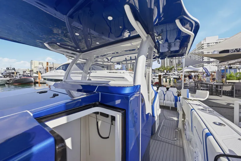 Slide: The Image of 2019 Midnight Express 43 Open boat with sleek blue and white design at a marina. - 17