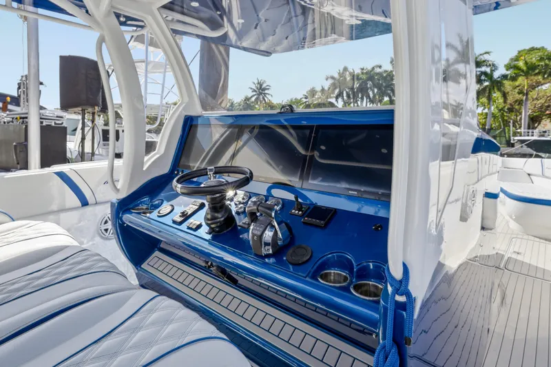 Slide: The Image of 2019 Midnight Express 43 Open boat cockpit with blue dashboard and steering wheel. - 2