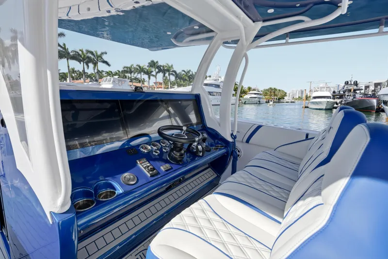 Slide: The Image of 2019 Midnight Express 43 Open boat interior with blue and white seating, docked near palm trees. - 4