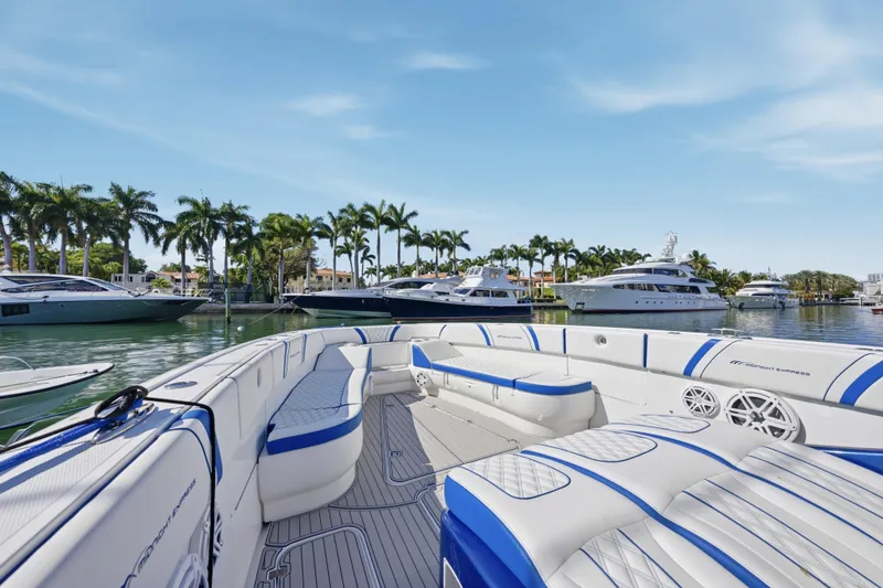 Slide: The Image of 2019 Midnight Express 43 Open boat with luxurious seating, docked near palm trees and yachts. - 9