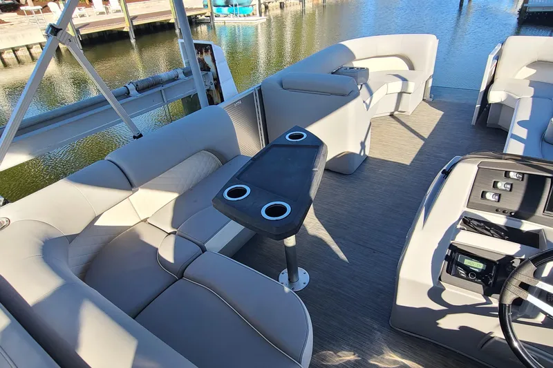 Slide: The Image of 2023 Bennington L23 pontoon boat interior with plush seating and modern controls. - 11