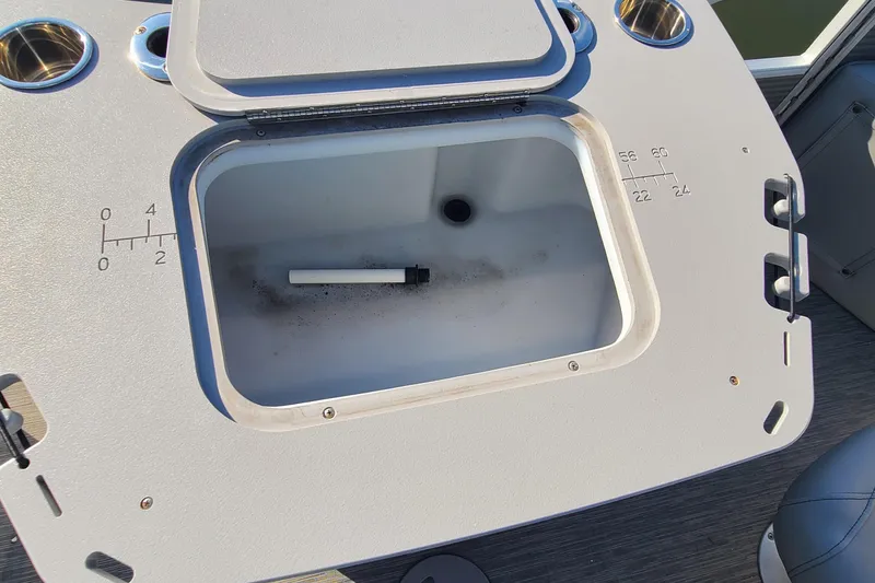 Slide: The Image of Open storage compartment on 2023 Bennington L23 boat with measurement markings. - 19