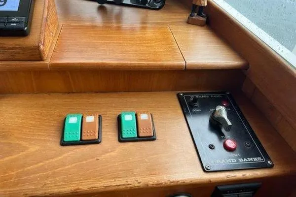 Slide: The Image of Control panel of a 2000 Grand Banks 36 Classic boat with switches and key. - 12