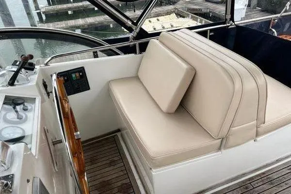 Slide: The Image of Helm seating area of 2000 Grand Banks 36 Classic yacht with beige cushions. - 3