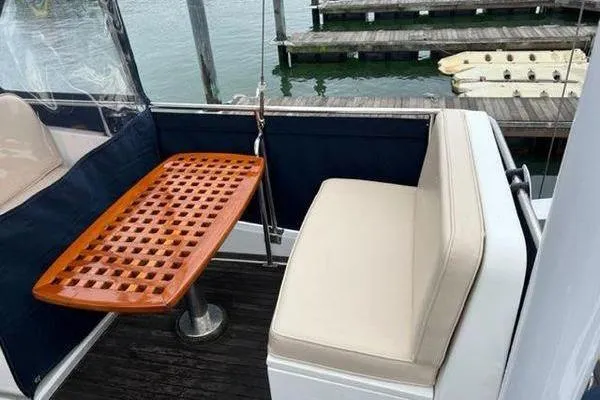 Slide: The Image of Grand Banks 36 Classic 2000 yacht with cushioned seating and wooden table on deck. - 4