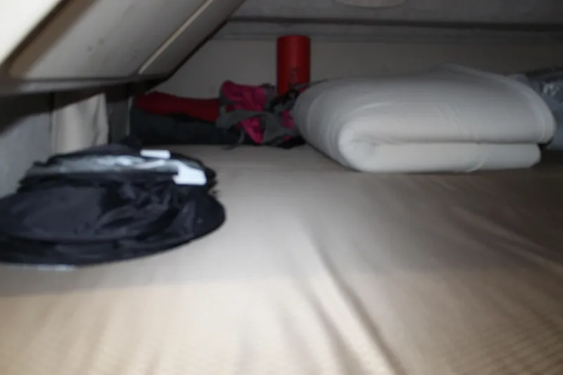Slide: The Image of Storage area inside Aspen B100, 2016 model, with folded bedding and camping gear. - 13