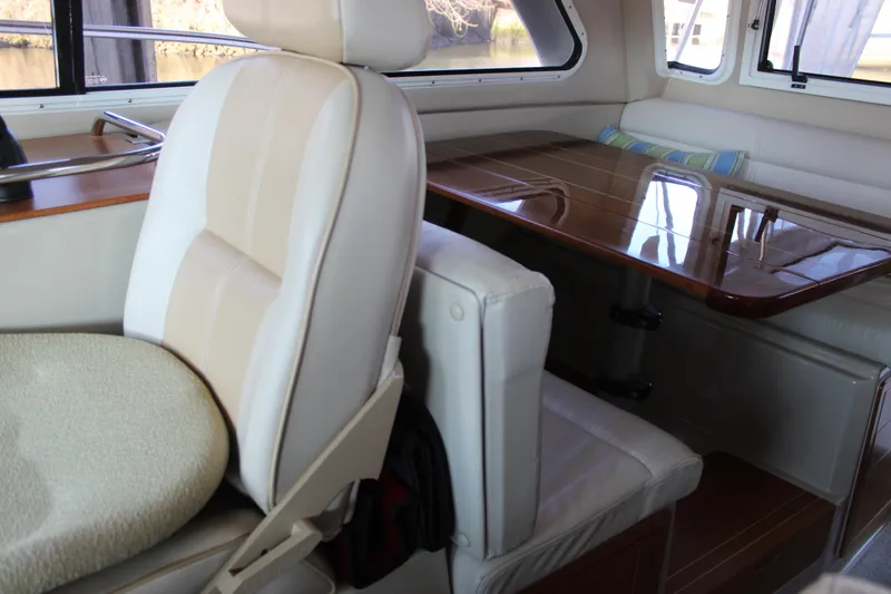 Slide: The Image of 2016 Aspen B100 boat interior with cushioned seating and polished wooden table. - 20