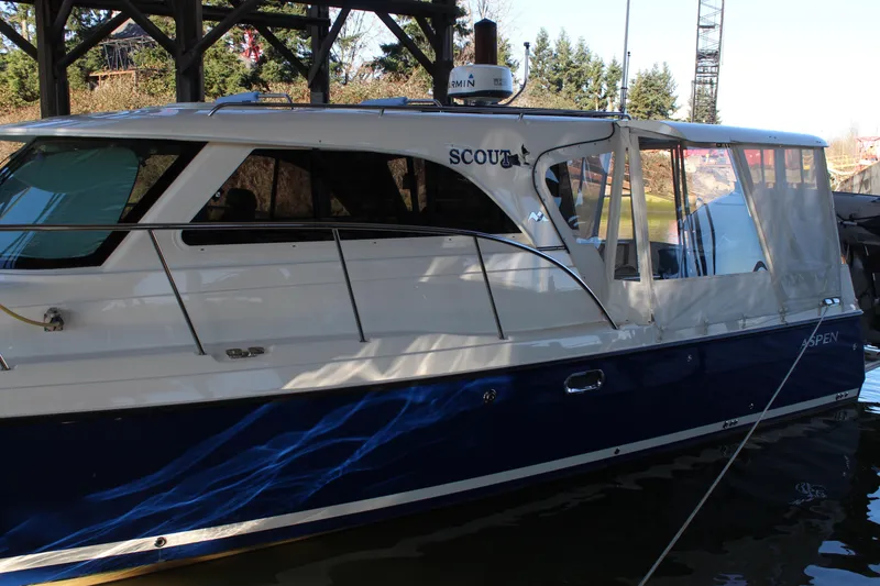Slide: The Image of 2016 Aspen B100 boat docked under a wooden structure. - 5