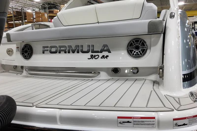 Slide: The Image of 2026 Formula 310 Bowrider OB boat rear view with speakers and branding. - 18