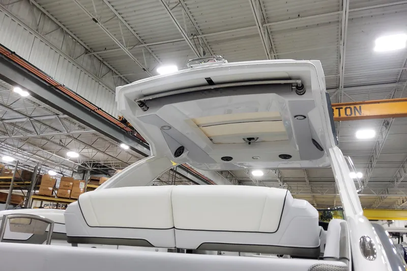 Slide: The Image of 2026 Formula 310 Bowrider OB boat interior with open sunroof in a warehouse setting. - 20