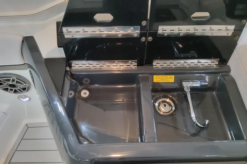 Slide: The Image of 2026 Formula 310 Bowrider OB boat sink with faucet and storage compartments. - 71