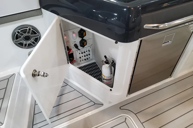 Slide: The Image of 2026 Formula 310 Bowrider OB interior with open storage compartment and fire extinguisher. - 79
