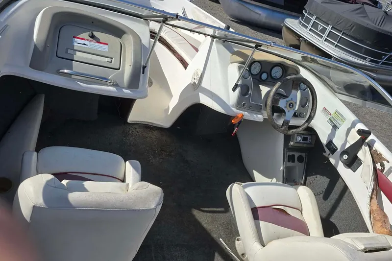 Slide: The Image of Interior of a 1998 Larson 190 Ski & Fish O/B boat, featuring steering wheel and seating. - 11