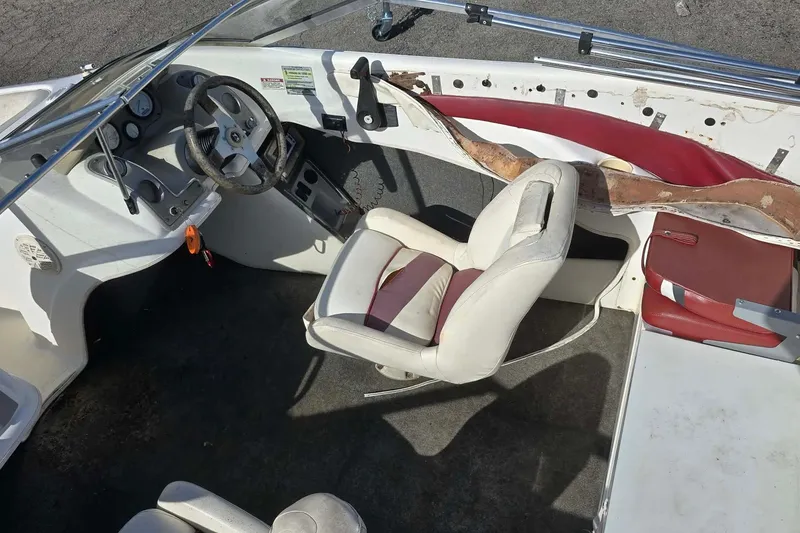 Slide: The Image of 1998 Larson 190 Ski & Fish O/B boat interior with worn seats and dashboard. - 12