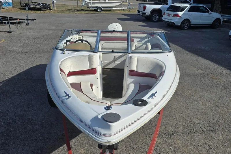 Slide: The Image of 1998 Larson 190 Ski & Fish O/B boat with red and white interior, parked outdoors. - 7