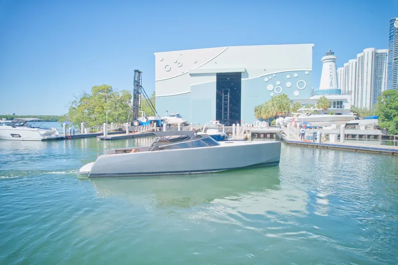 Slide: The Image of VanDutch 40 yacht cruising near a marina with modern buildings in the background, 2015 model. - 14