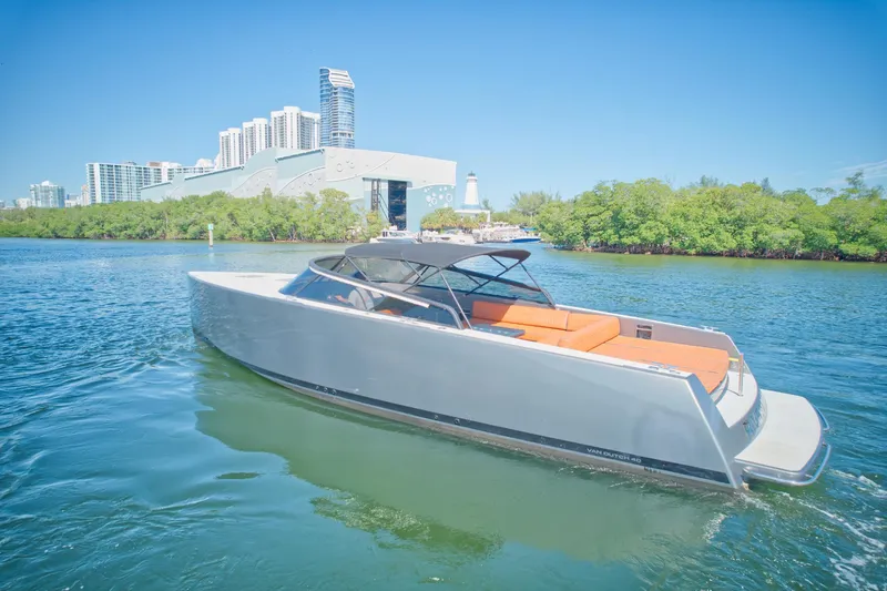 Slide: The Image of 2015 VanDutch 40 yacht cruising near modern cityscape and lush greenery. - 15