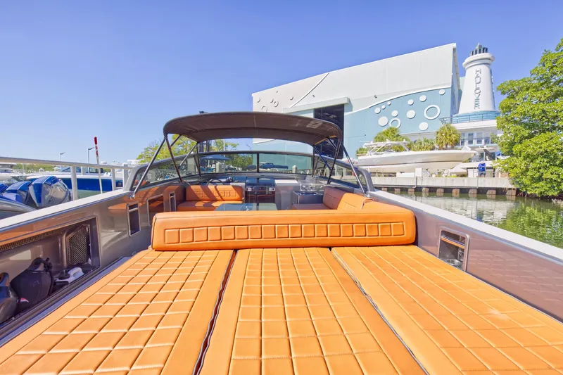 Slide: The Image of 2015 VanDutch 40 luxury yacht with orange seating, docked near a modern building. - 22