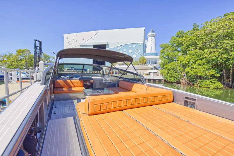 Slide: The Image of 2015 VanDutch 40 yacht with orange seating docked near a modern building and lighthouse. - 27