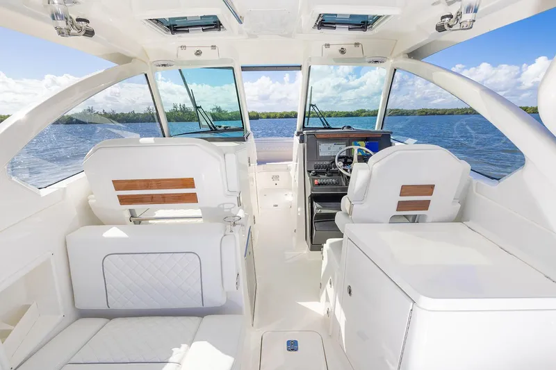 Slide: The Image of Manufacturer Provided Image: 2025 Pursuit DC 306 Dual Console boat interior with white seating and scenic water view. - 11