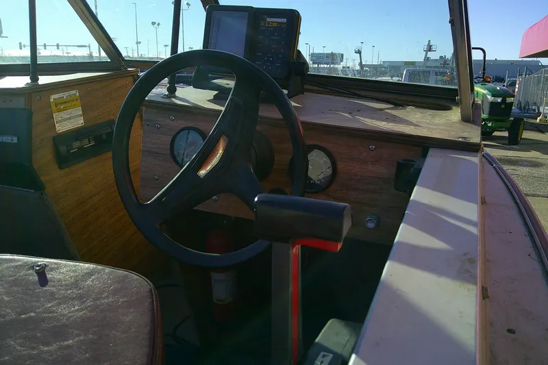 Slide: The Image of 1983 L 4.9 TYEE boat dashboard with steering wheel and gauges in sunlight. - 5