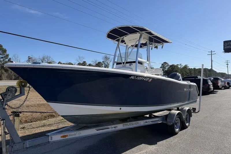 Slide: The Image of 2011 Sea Hunt Triton 225 boat on trailer, parked outdoors under clear sky. - 5