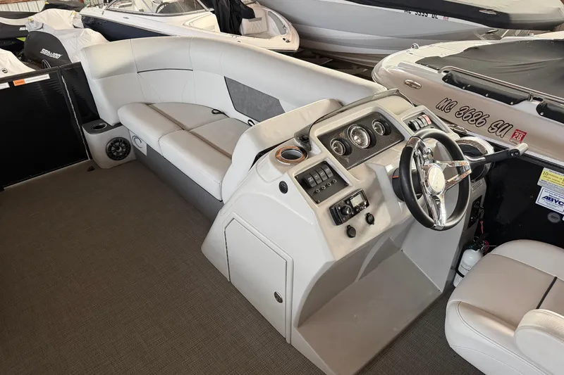 Slide: The Image of 2021 Crest Classic LX 200 L boat interior with steering console and seating area. - 15