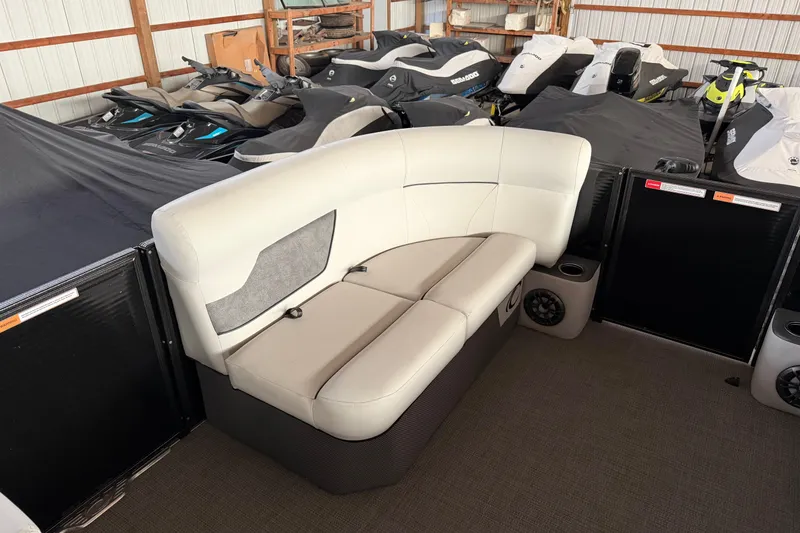 Slide: The Image of 2021 Crest Classic LX 200 L boat interior with cushioned seating and covered jet skis. - 16