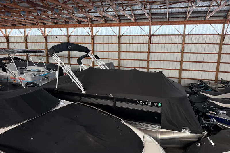 Slide: The Image of 2021 Crest Classic LX 200 L pontoon boat covered in storage facility. - 3