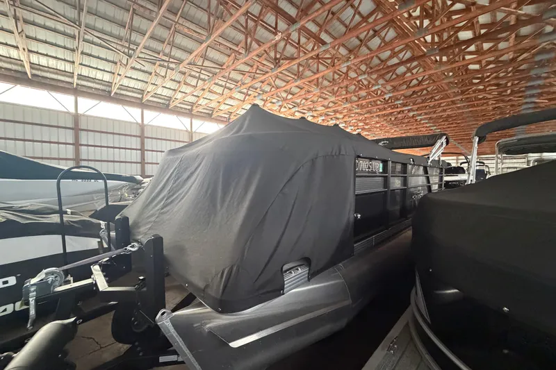 Slide: The Image of 2021 Crest Classic LX 200 L pontoon boat covered in storage facility. - 4