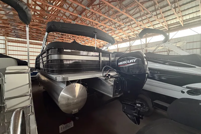 Slide: The Image of 2021 Crest Classic LX 200 L pontoon boat with Mercury engine in storage. - 5