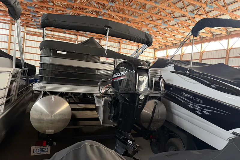 Slide: The Image of 2021 Crest Classic LX 200 L pontoon boat with Mercury 60 engine in storage. - 6