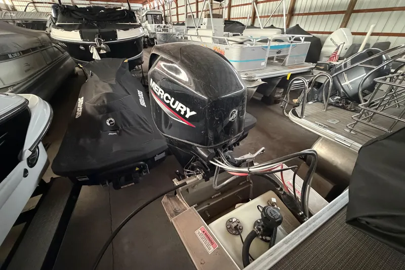 Slide: The Image of 2021 Crest Classic LX 200 L pontoon boat with Mercury outboard motor in storage. - 8