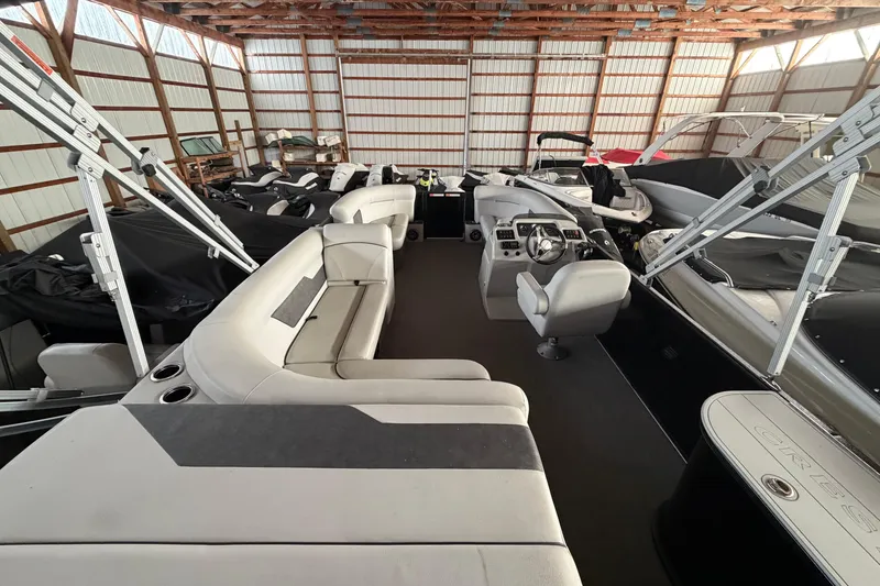 Slide: The Image of 2021 Crest Classic LX 200 L pontoon boat interior in storage facility. - 9