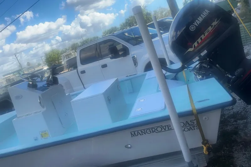Slide: The Image of 2025 Mangrove Coast Boats 1700 Harbor Hawk with Yamaha engine, parked beside a white truck. - 3