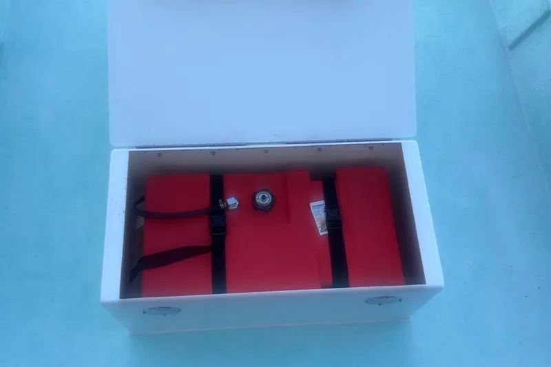 Slide: The Image of Open storage compartment in 2025 Mangrove Coast Boats 1700 Harbor Hawk, featuring red safety equipment. - 6