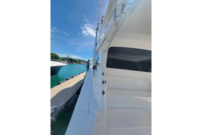 Slide: The Image of Side view of a 2012 Viking 64c yacht docked by a serene marina. - 10