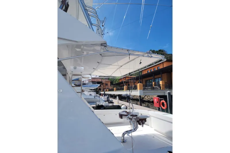 Slide: The Image of 2012 Viking 64c yacht docked, showcasing sleek design and fishing equipment under a clear blue sky. - 11