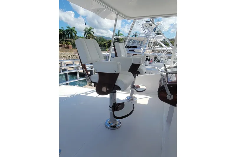 Slide: The Image of Luxury seating on 2012 Viking 64c yacht, featuring sleek white chairs and ocean backdrop. - 15