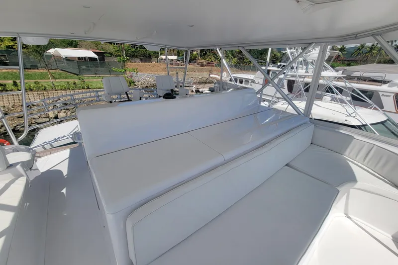 Slide: The Image of Spacious seating area on a 2012 Viking 64c yacht, docked with scenic background. - 23