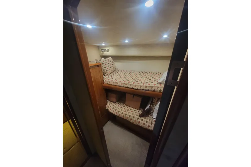 Slide: The Image of Cozy bunk bed cabin in 2012 Viking 64 Convertible yacht, featuring patterned bedding and warm lighting. - 46