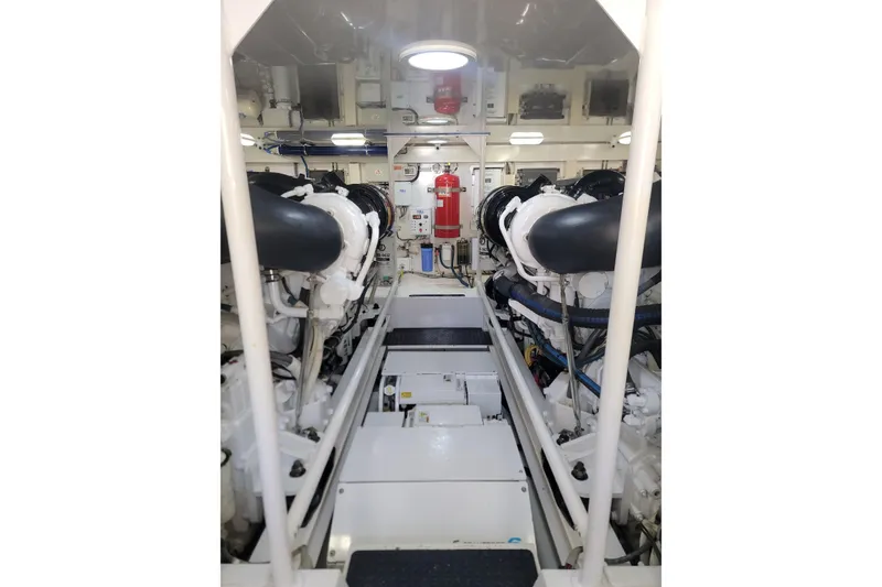 Slide: The Image of Engine room of a 2012 Viking 64c yacht, featuring dual engines and safety equipment. - 49
