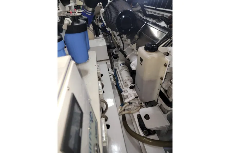 Slide: The Image of Engine room of a 2012 Viking 64c yacht, showcasing mechanical components and fluid containers. - 57