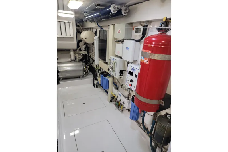 Slide: The Image of Engine room of 2012 Viking 64c yacht with equipment and red fire extinguisher. - 64