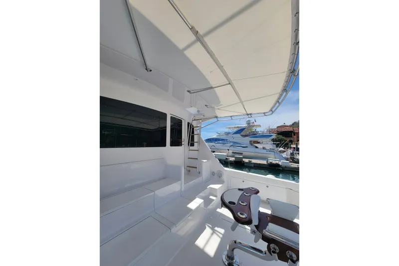 Slide: The Image of 2012 Viking 64c yacht deck with seating and fishing chair, docked at marina. - 9