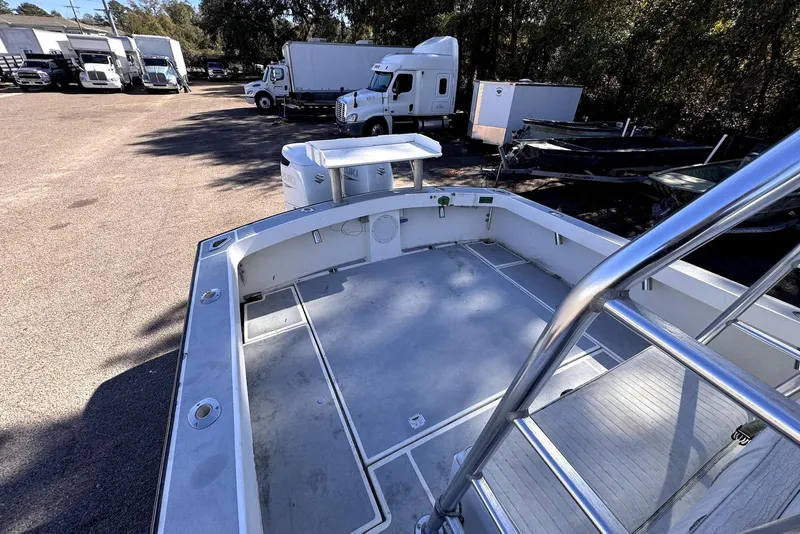 Slide: The Image of 2005 Mirage SF32 Center Console boat in a parking lot with trucks. - 13